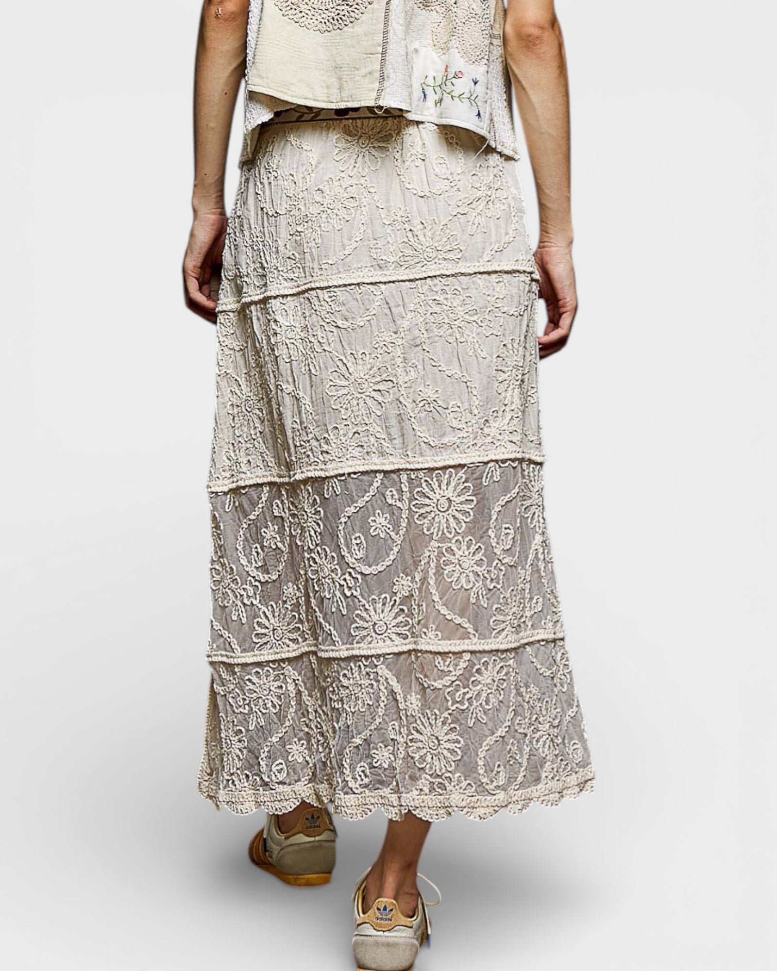 Person wearing a layered lace dress on a white background