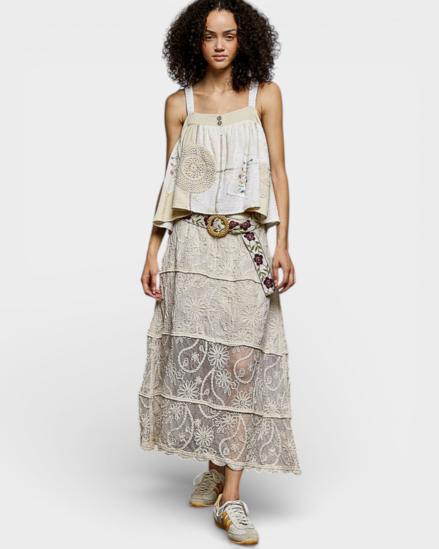 Woman wearing a layered dress with floral patterns on a white background