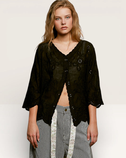 Woman wearing a black lace top and striped pants on a white background