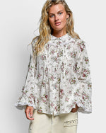 Woman wearing a floral blouse against a white background