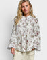 Woman wearing a floral blouse against a white background