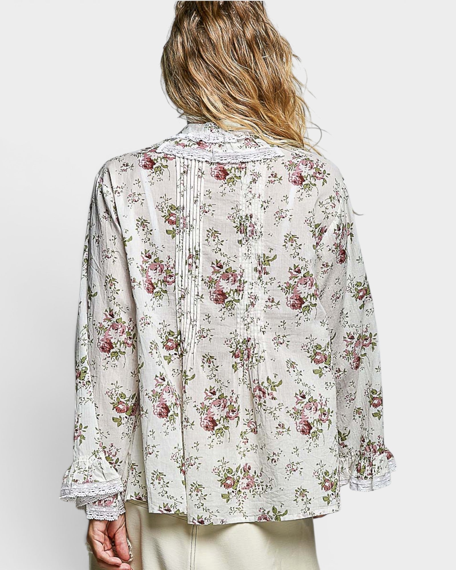 Floral patterned blouse worn by a person on a white background