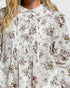 Floral patterned blouse with a focus on the fabric texture and design.