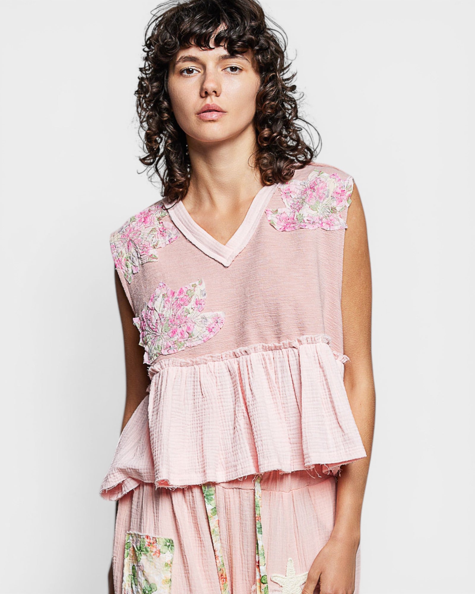 Woman wearing a pink floral dress against a white background