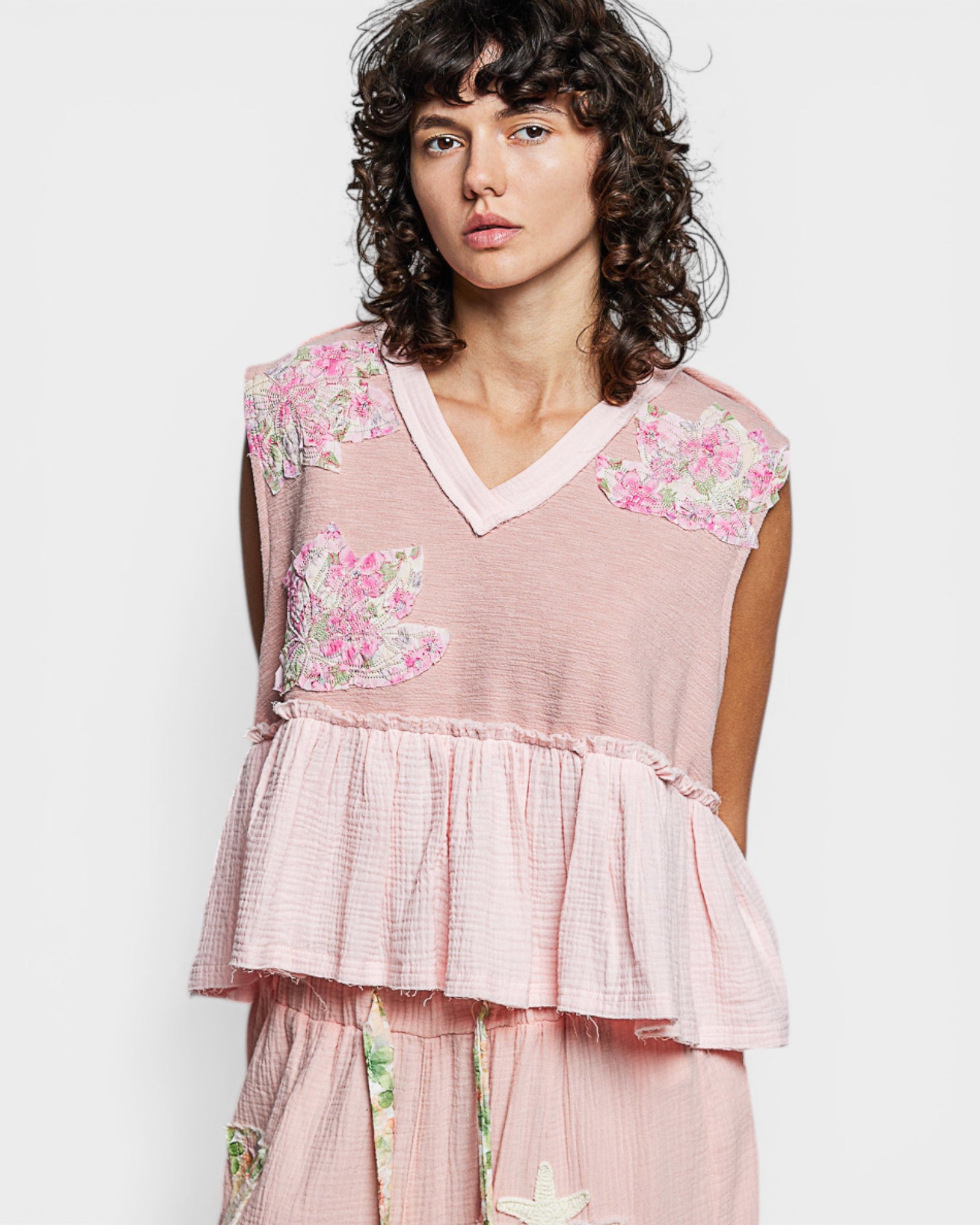 Woman wearing a pink floral dress against a white background