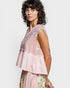 Woman wearing a pink embroidered top with a white background