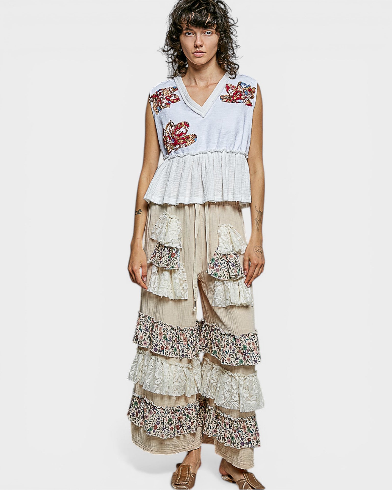 Woman wearing a layered dress with floral patterns on a white background