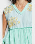 Mint green dress with floral patterns on a plain background