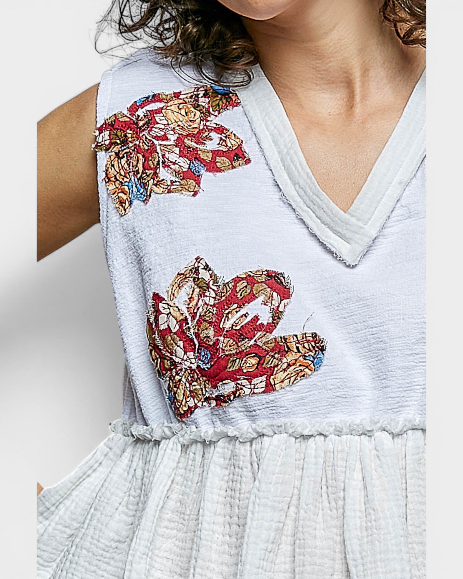 White dress with colorful floral embroidery on a plain background