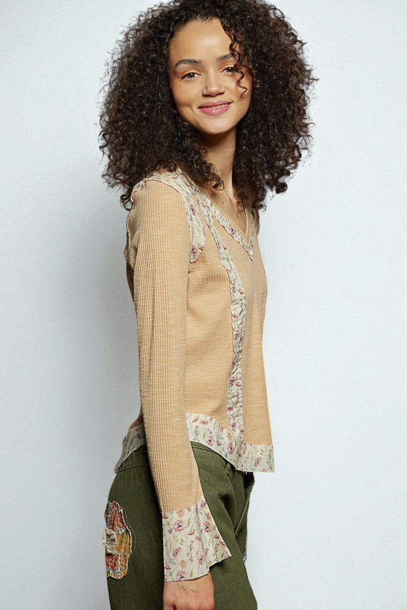 Woman wearing a beige blouse with floral patterns on a white background