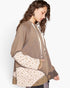 A woman wearing a brown patchwork hoodie with cream-colored drawstrings and patterned sleeves, shown from a side profile against a plain white background.