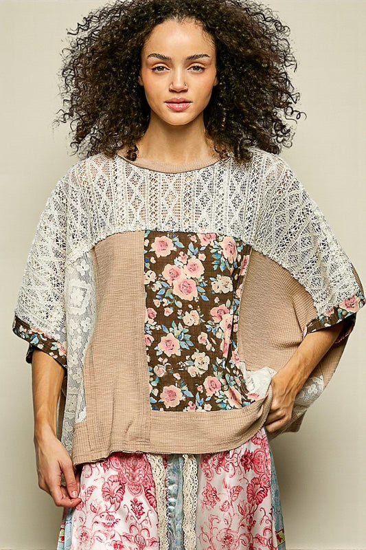 Woman wearing a layered outfit with lace, floral, and plain pieces against a neutral background