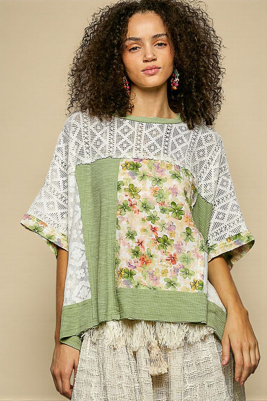 Woman wearing a floral and lace top with a beige background