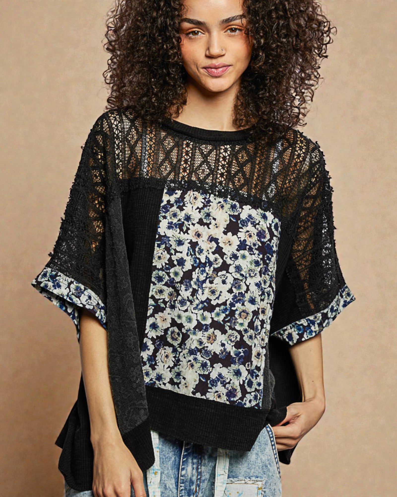 Woman wearing a black and floral patterned top against a beige background