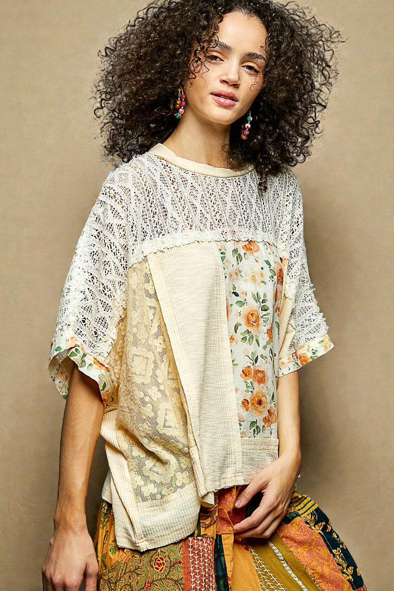 Woman wearing a floral blouse with a beige cardigan against a neutral background