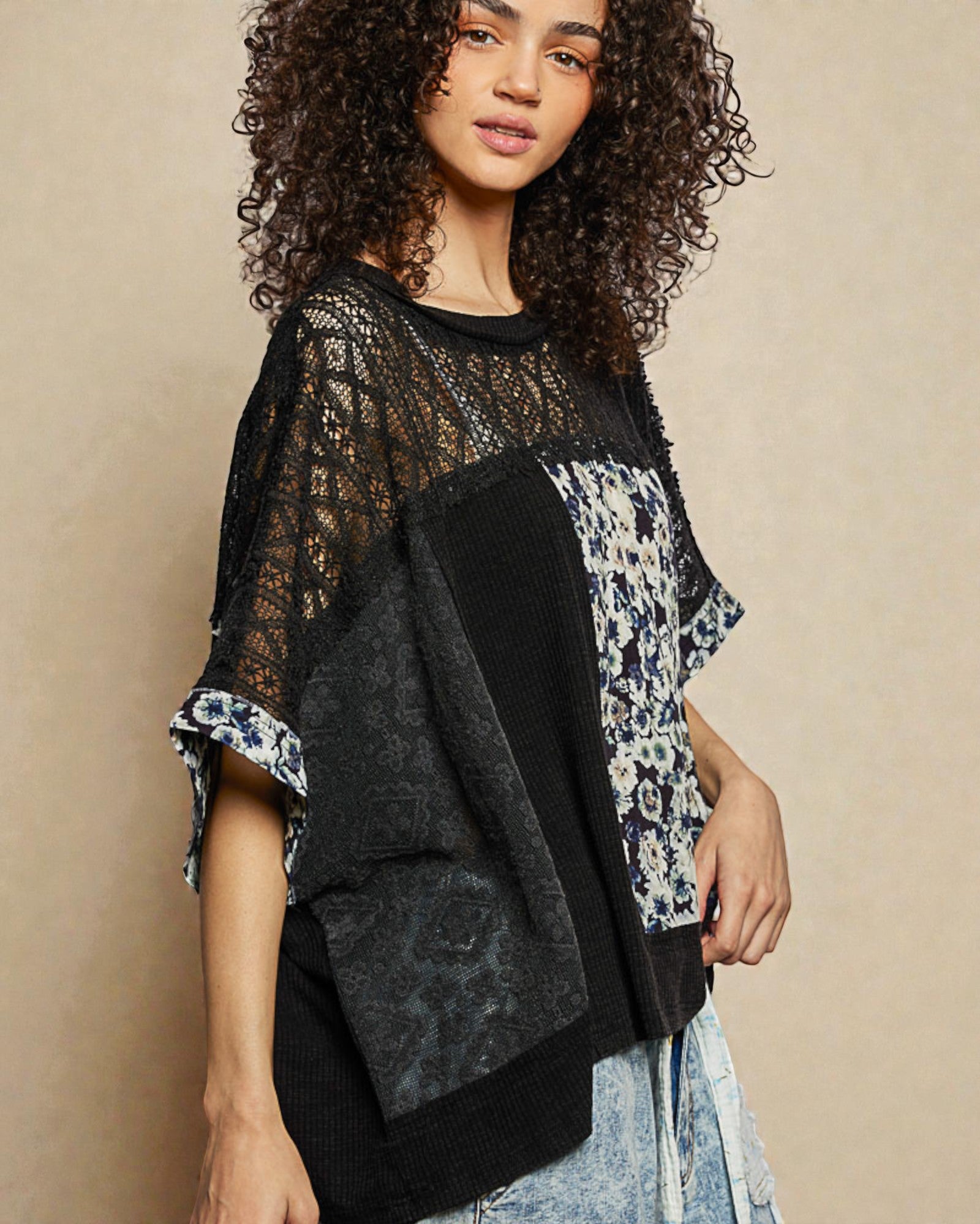 Woman wearing a black and floral patterned top against a beige background