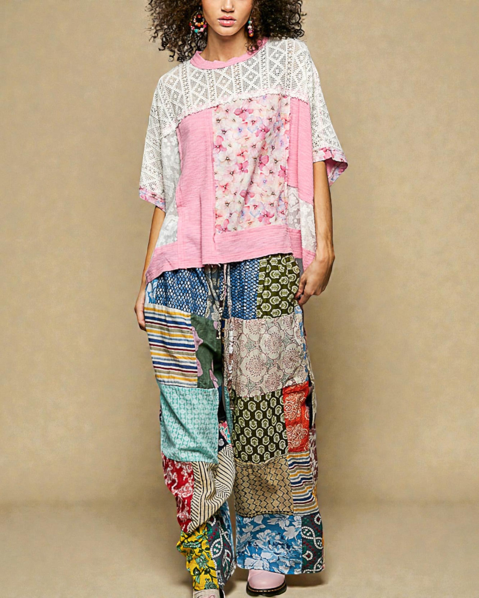 Person wearing a colorful patchwork outfit with a plain background