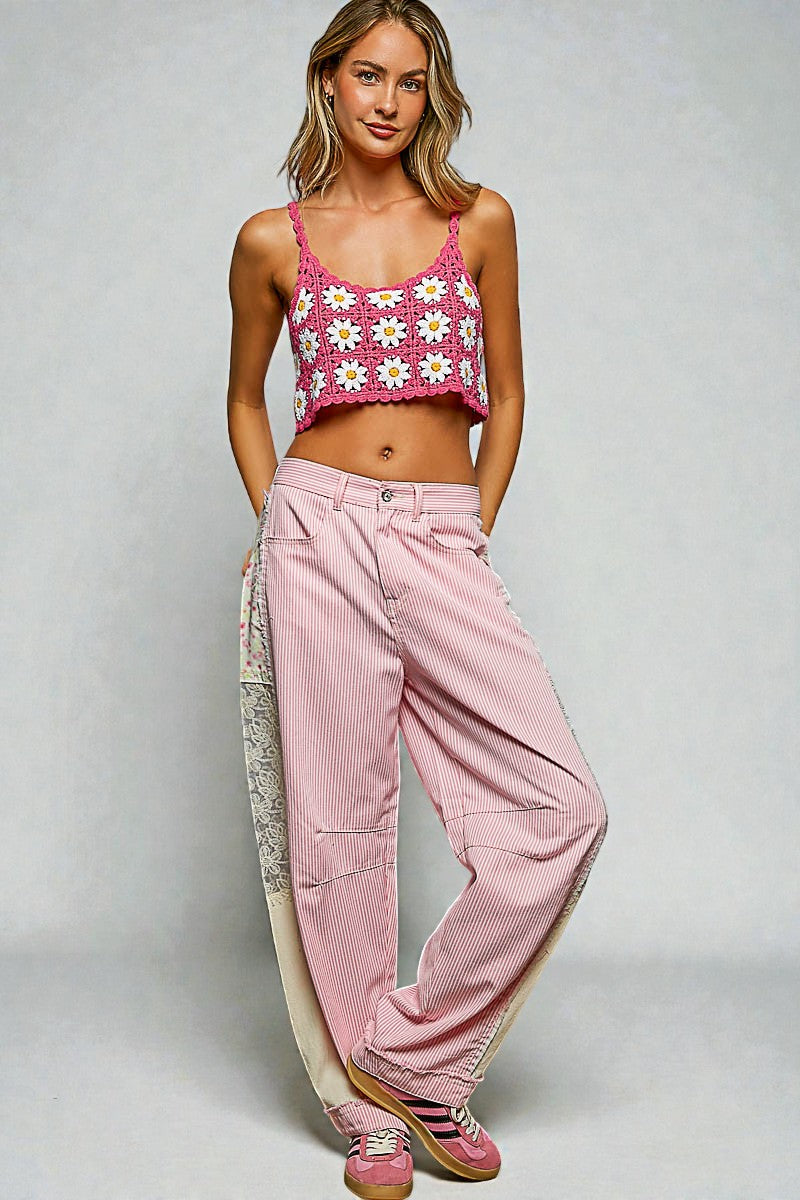 Woman wearing a pink floral crop top and pink pants on a gray background