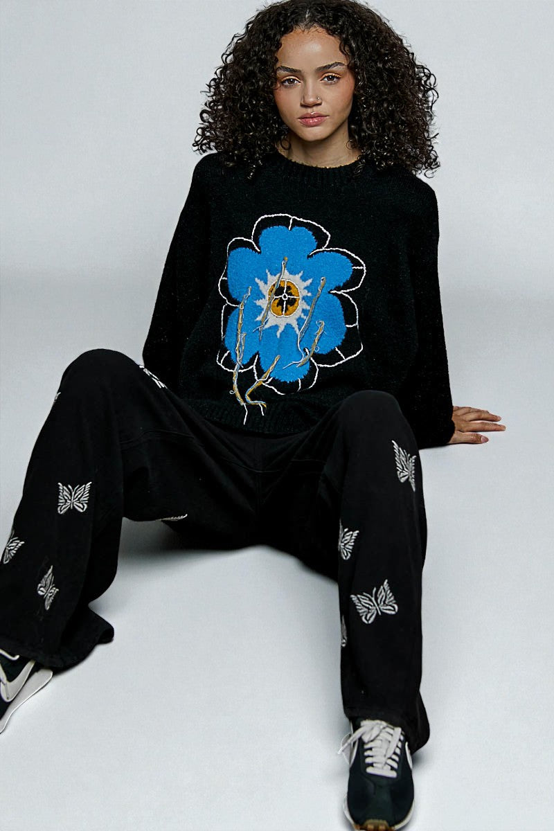 Person wearing a black outfit with a blue floral design on a white background