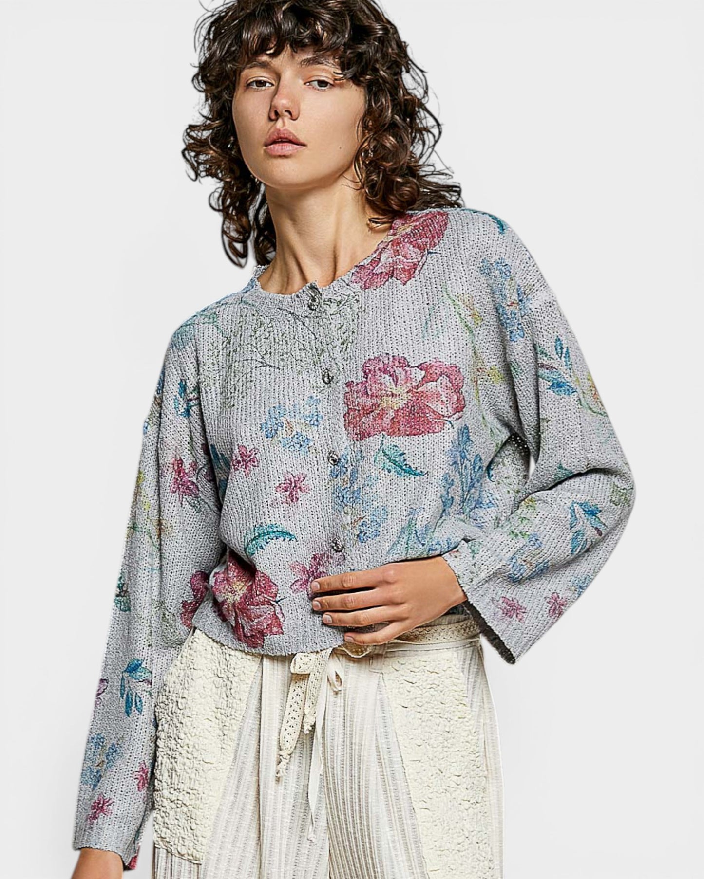 Woman wearing a floral patterned sweater on a plain background