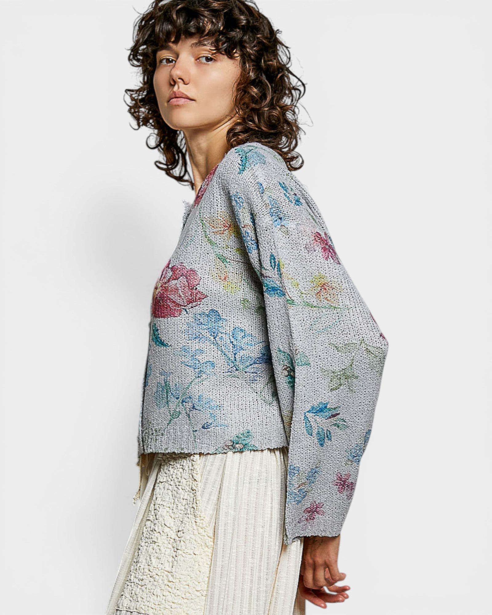 Woman wearing a floral-patterned cardigan on a white background