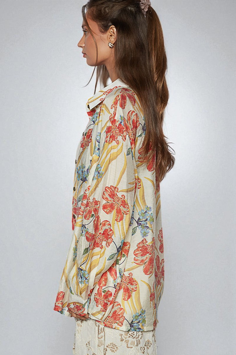 Woman wearing a colorful floral blouse against a plain background