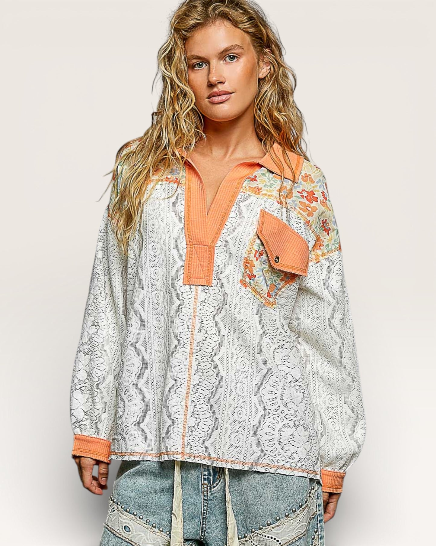 Woman wearing a patterned shirt with orange accents on a white background