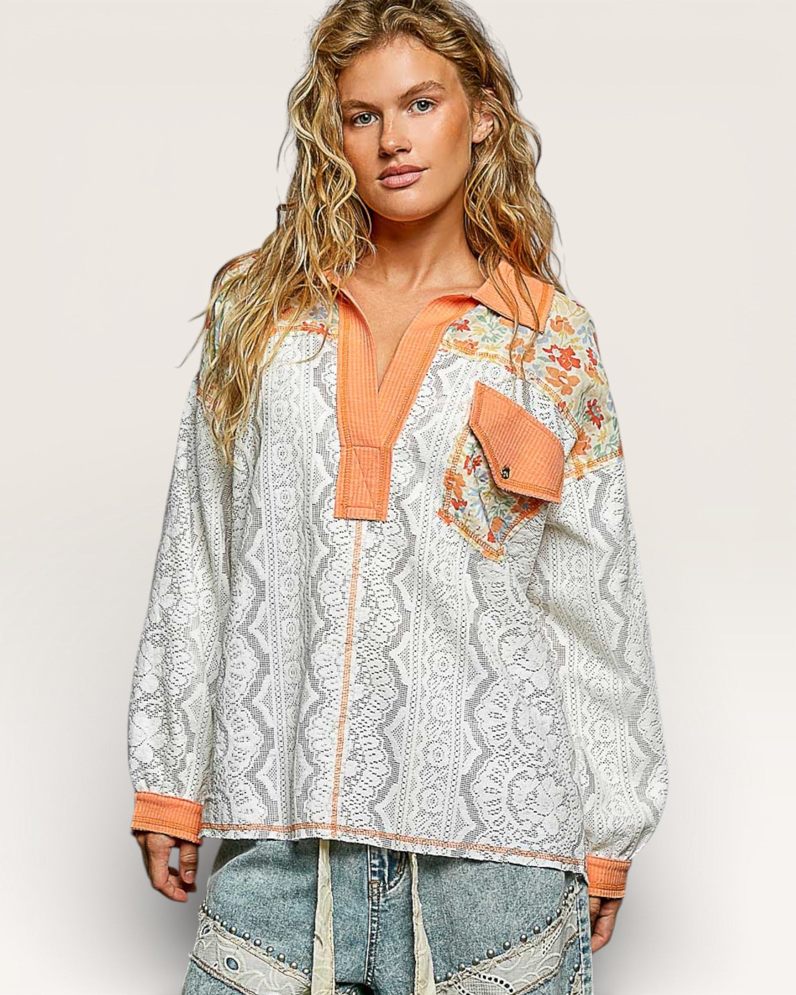 Woman wearing a patterned shirt with orange accents on a white background