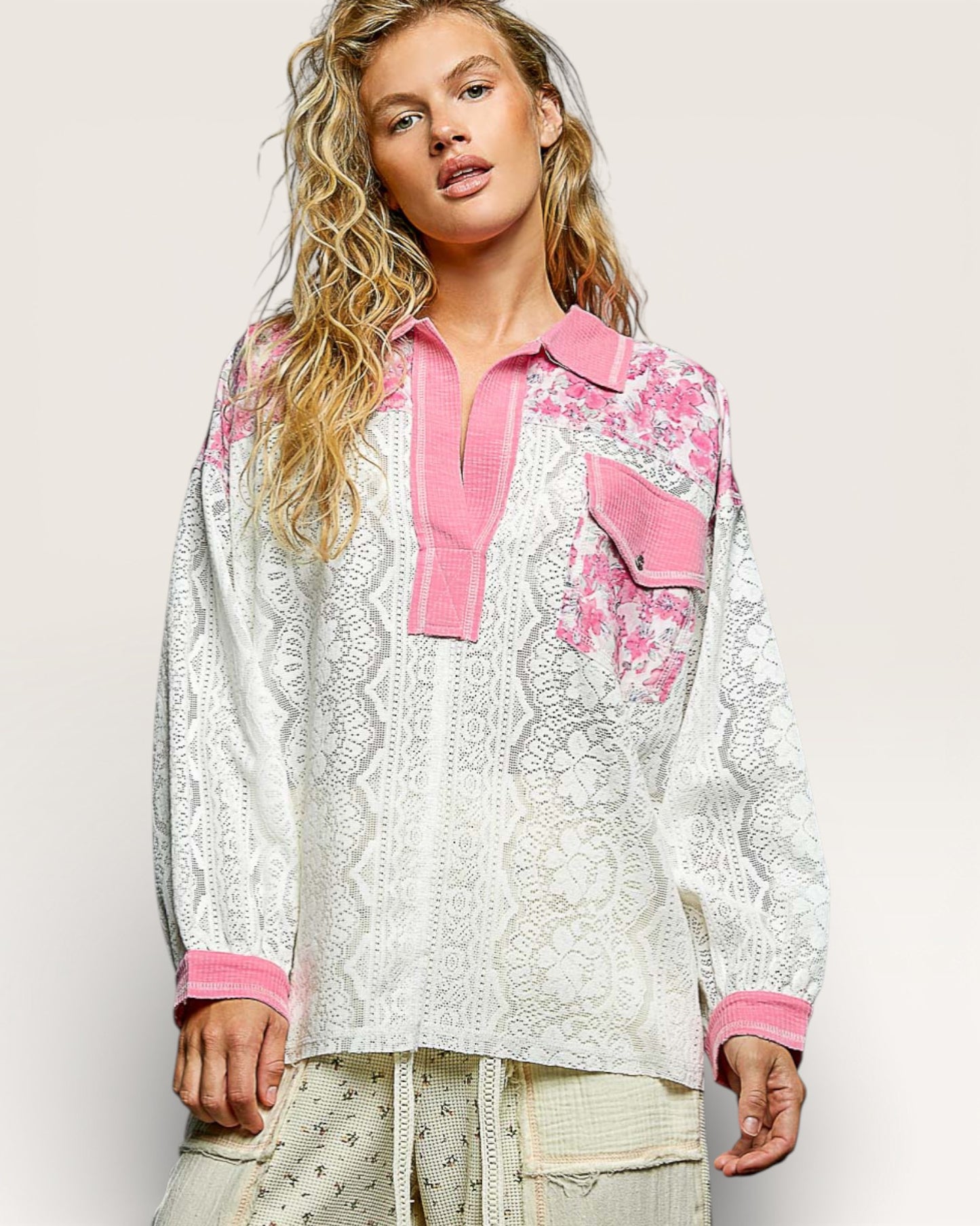 Woman wearing a floral blouse with pink accents on a plain background