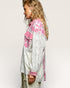 Person wearing a white and pink patterned jacket on a plain background