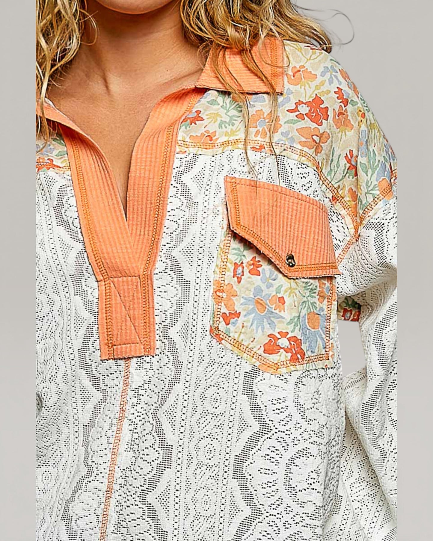 Floral and lace patterned jacket with orange accents on a gray background