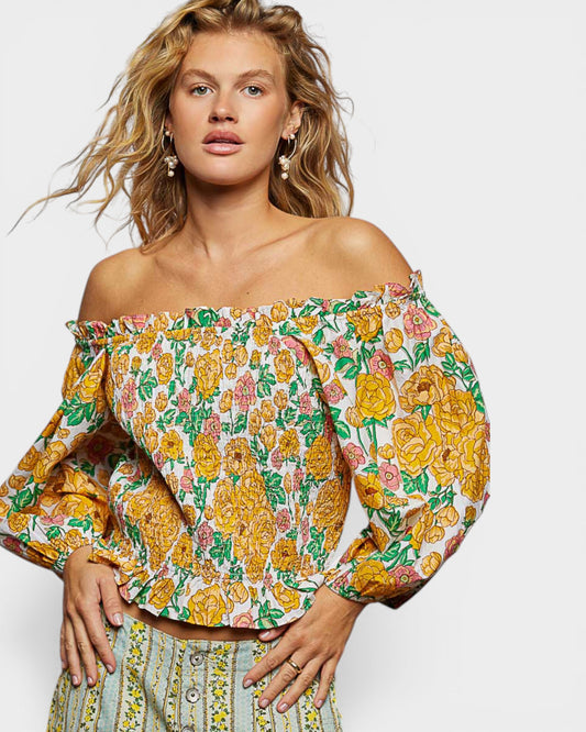 Woman wearing a floral off-shoulder top on a white background