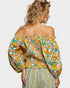 Woman wearing a floral off-shoulder top with puffed sleeves on a plain background