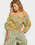 Woman wearing a floral off-shoulder top with matching pants on a white background