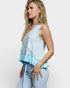 Woman wearing a light blue ruffled top and pants on a white background