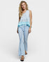 Woman wearing a light blue sleeveless top and pants on a white background
