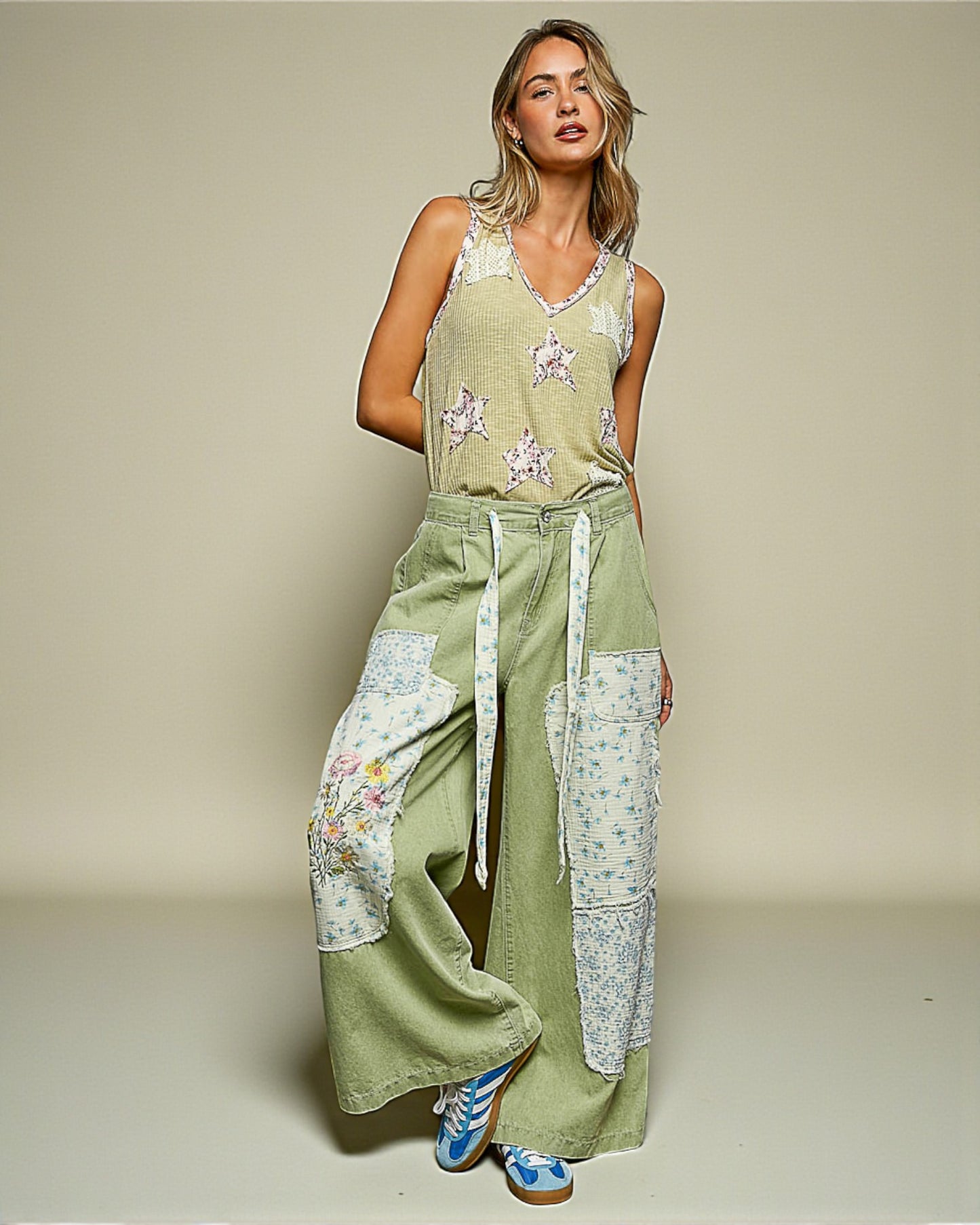 Woman wearing a green floral jumpsuit on a beige background