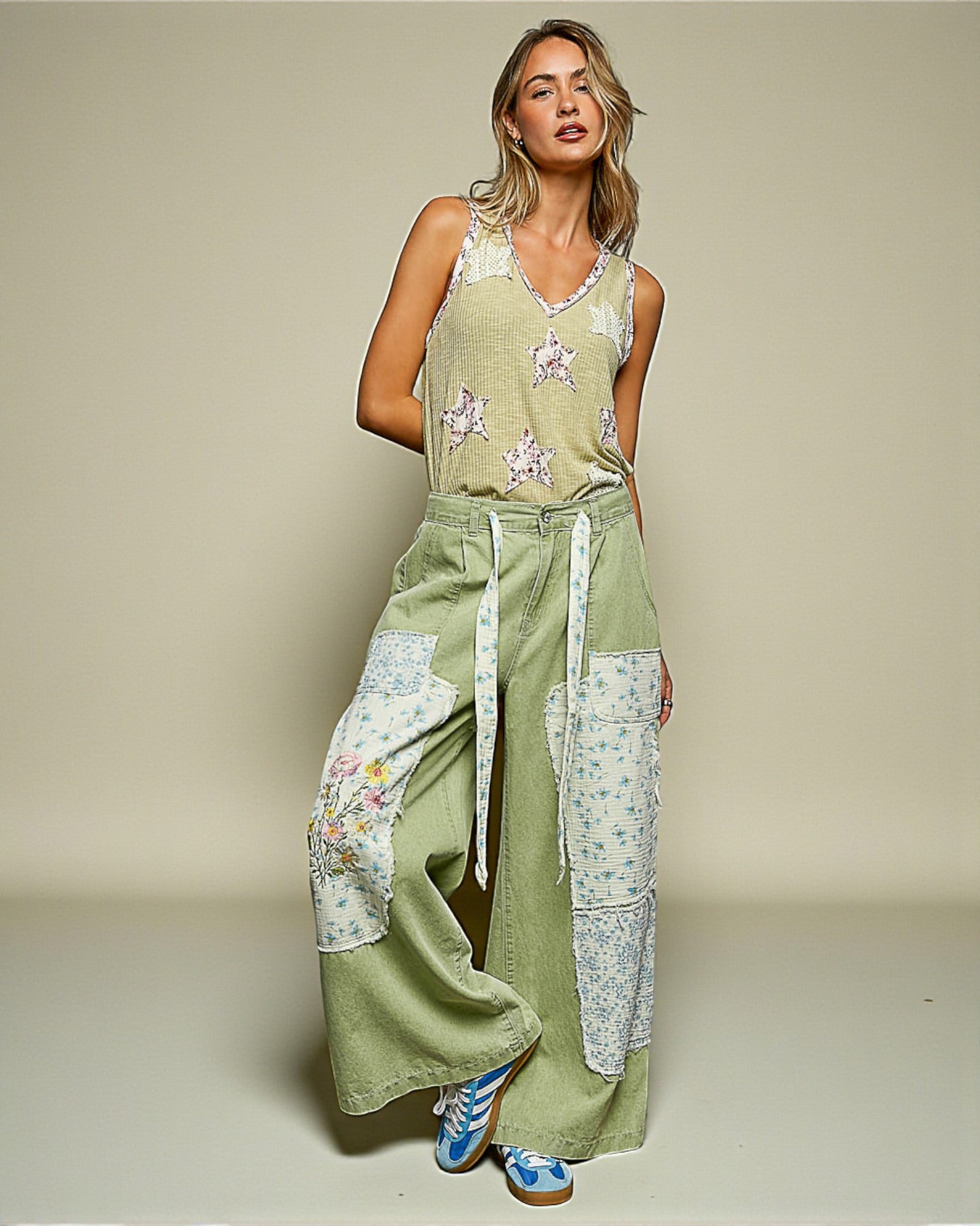 Woman wearing a green floral jumpsuit on a beige background