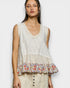 Woman wearing a sleeveless top with floral hem on a white background