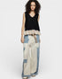 Woman wearing a black sleeveless top and patterned pants on a white background