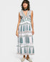 Woman wearing a sleeveless dress with leaf pattern on a white background