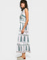 Woman wearing a white dress with green leaf patterns on a white background