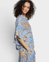 Woman wearing a blue floral outfit against a white background