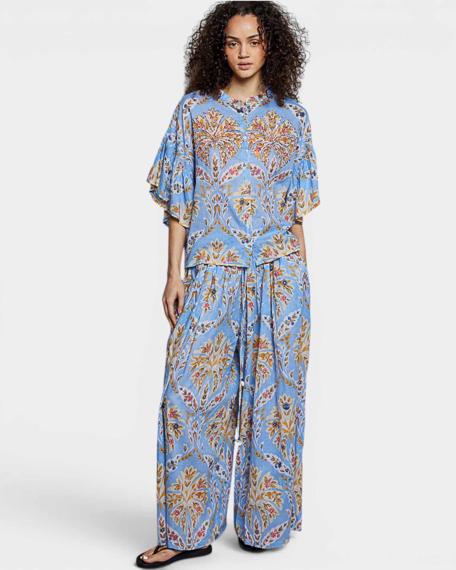 Woman wearing a blue floral outfit on a white background