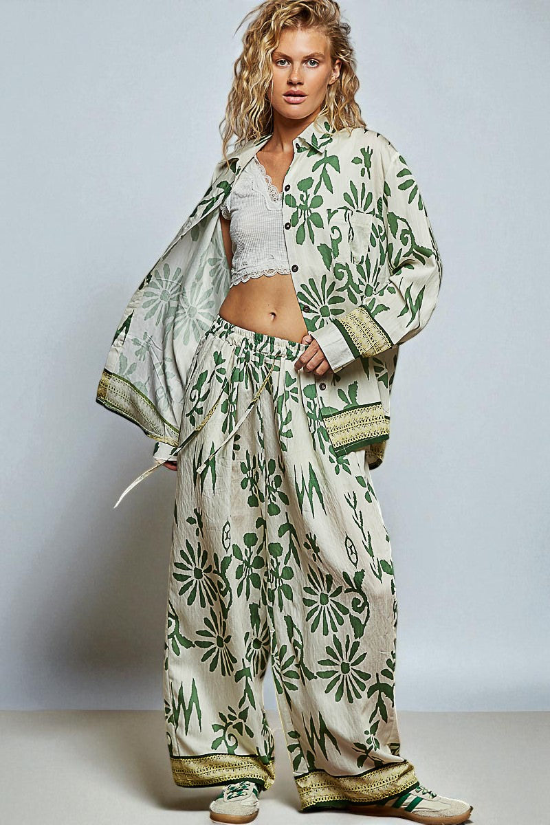 Woman wearing a green and white floral outfit against a plain background