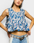Woman wearing a blue floral sleeveless top against a white background