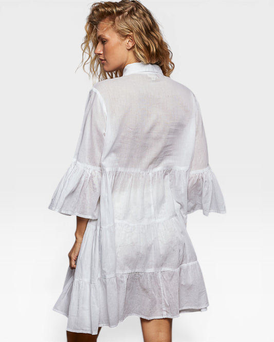 Woman wearing a white dress with ruffled sleeves on a white background