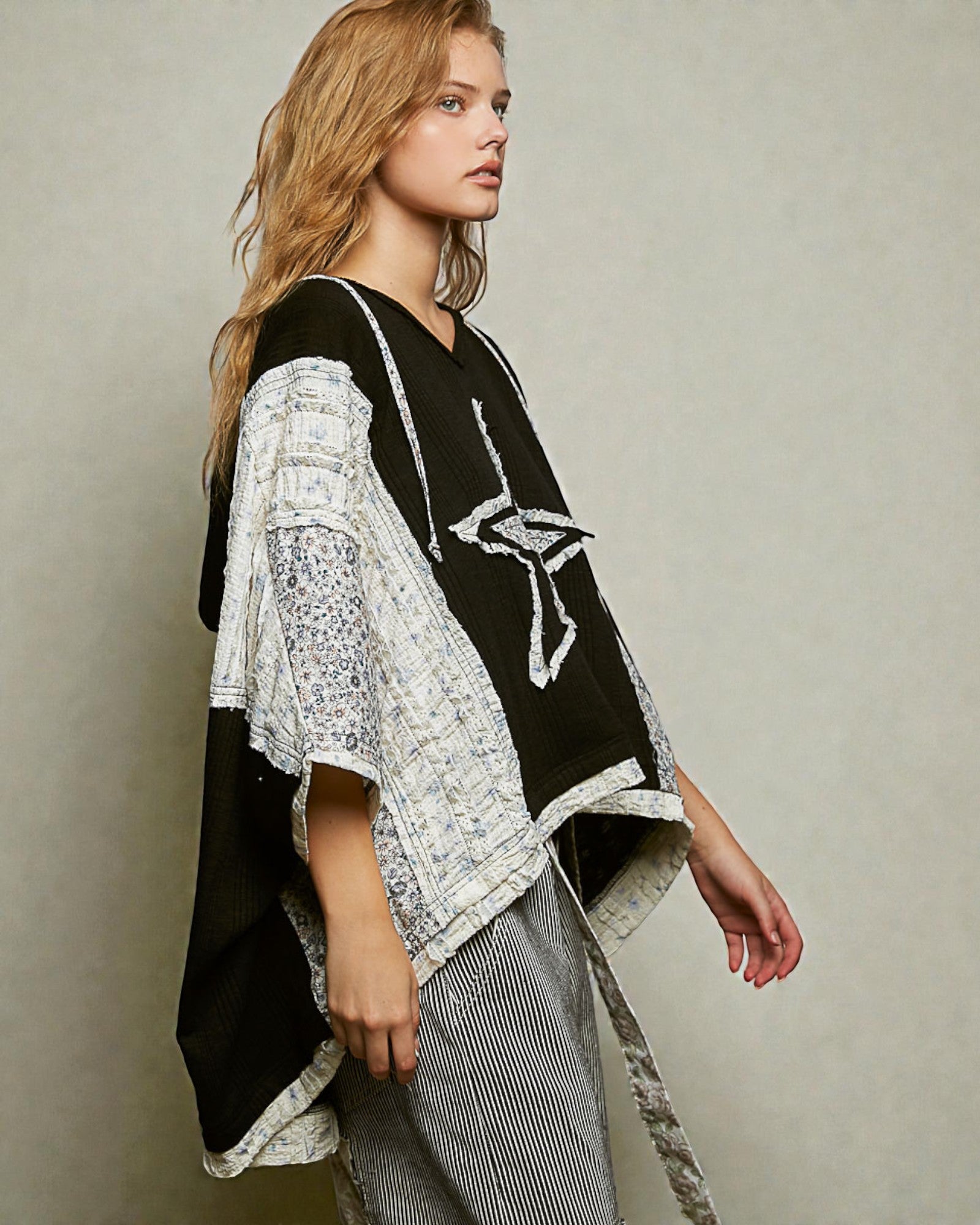 Woman wearing a black and white outfit with a star design on a plain background