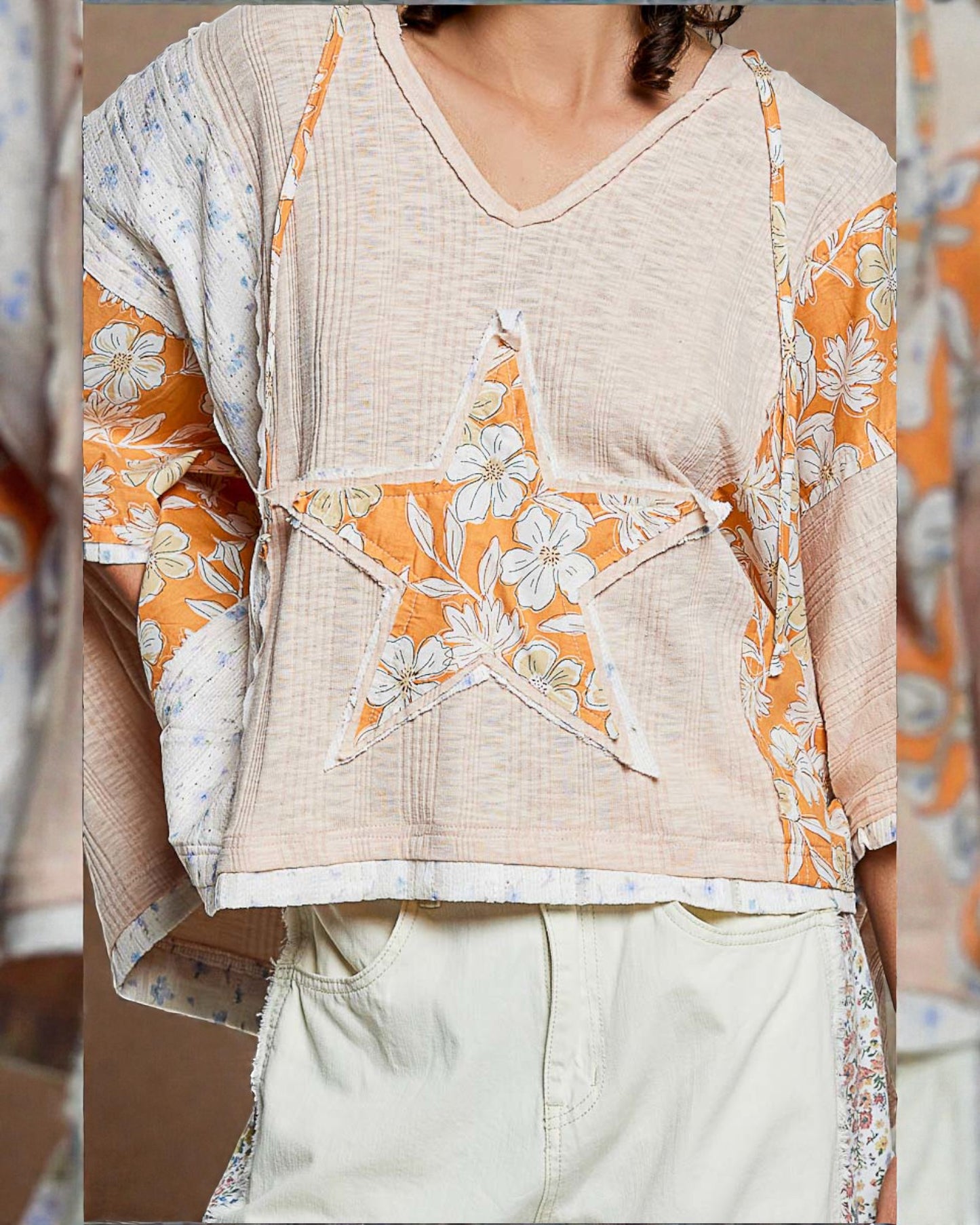 Beige top with orange and white floral patterns worn by a person