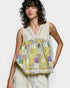 Woman wearing a sleeveless, patchwork top with a plain background